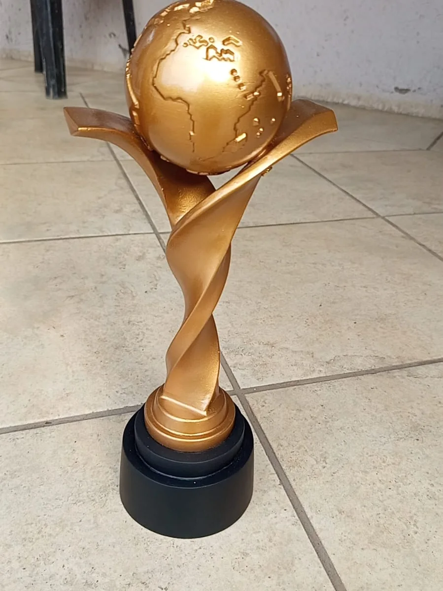 Finished gold custom globe trophy with twisted pedestal on a black base, designed by Enginova.