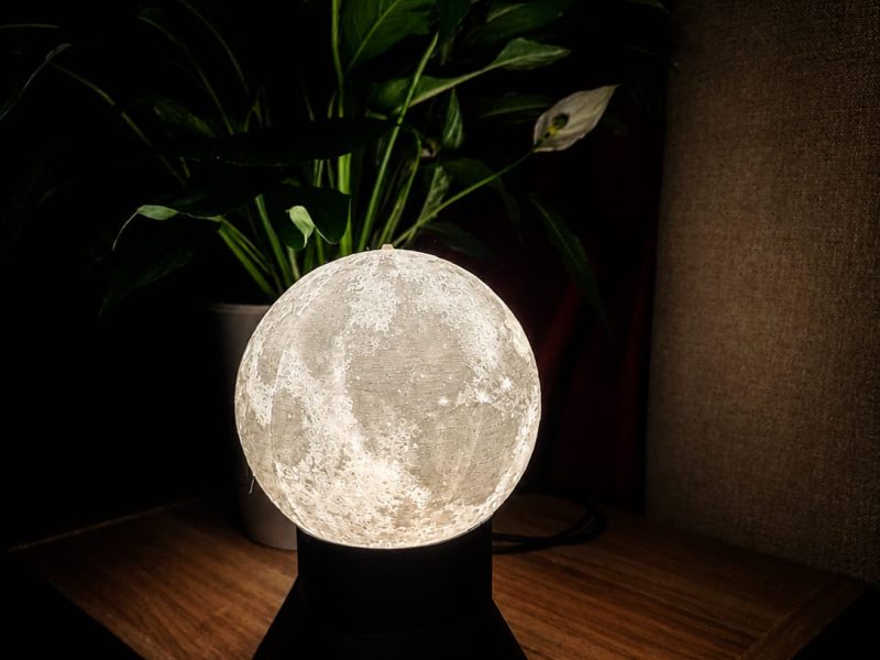 Textured 3D-printed moon lamp lit for warm home lighting.