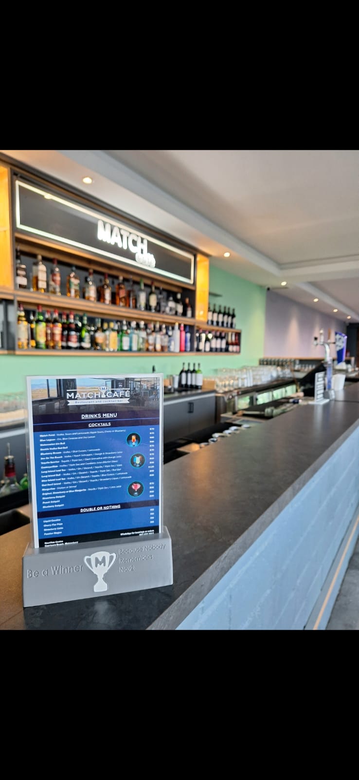 Custom 3D-printed menu holder on a table at The Match Café in Muizenberg.